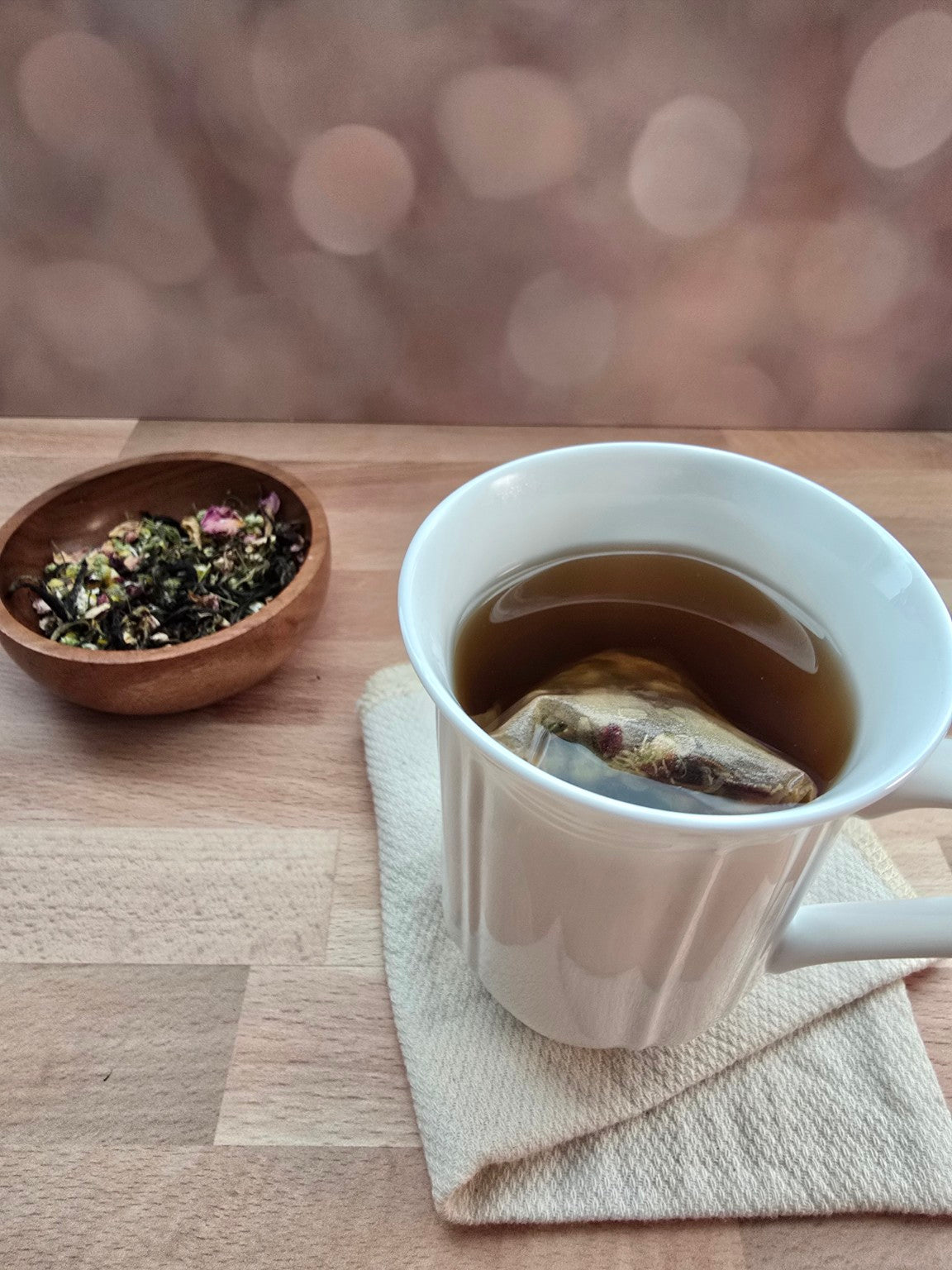 Freshly brewed custom tea beside loose leaf ingredients from the Tea Blending Gathering experience