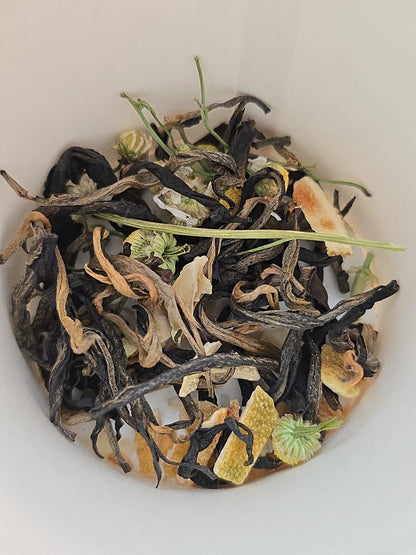 Custom tea blend featuring black tea, chamomile, and citrus botanicals inside a blending cup