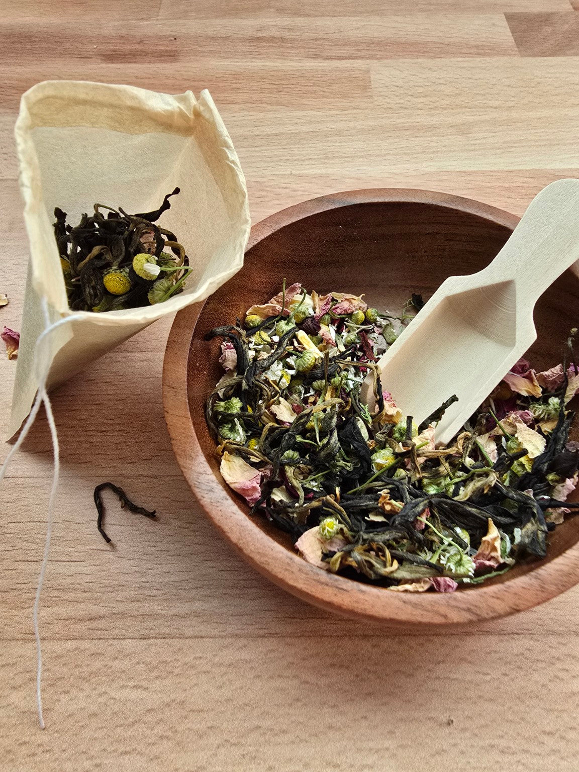 Handcrafted tea blend being scooped into a tea bag during a tea blending gathering activity