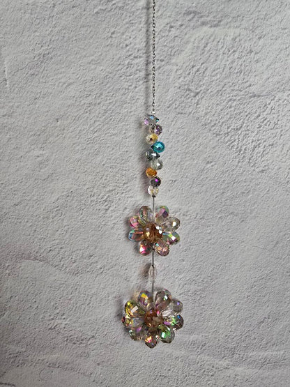 Floral Radiance Suncatcher featuring two stacked iridescent crystal flowers with a vertical beaded stem in soft rainbow tones