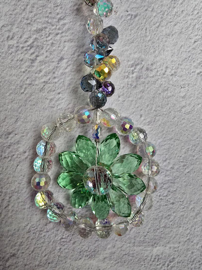 Close-up of the Verdant Light Bloom suncatcher highlighting the green crystal petals, central round crystal, and shimmering beadwork