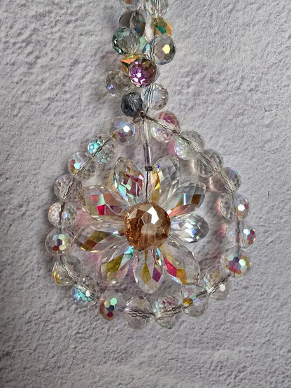 Close-up of the Crystal Petal Radiance suncatcher showing the iridescent clear crystal petals and reflective accent beads
