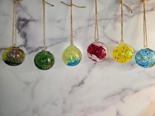 Collection of hand-blown glass orbs hanging from twine, each in different swirled colors