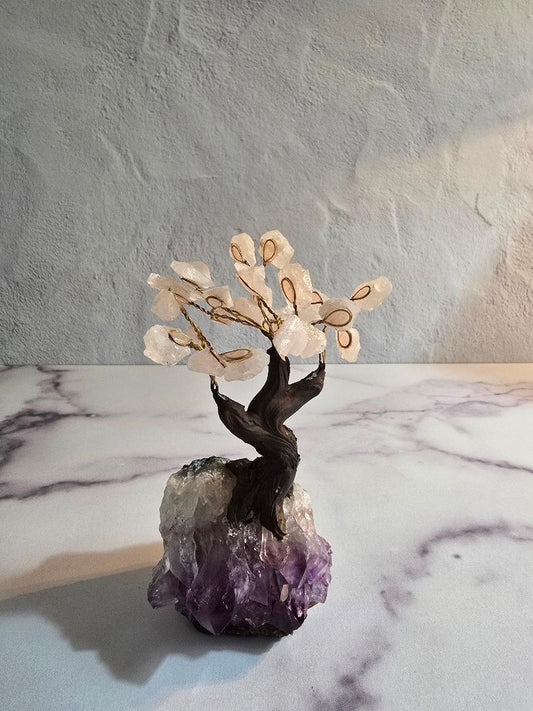 Rose quartz gemstone tree with wire branches and a natural amethyst and quartz base, displayed on a marble surface