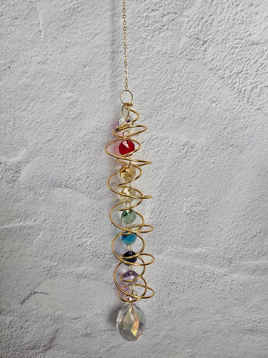 Full view of the gold Chakra Spiral Suncatcher with rainbow chakra beads and a large faceted crystal prism at the bottom