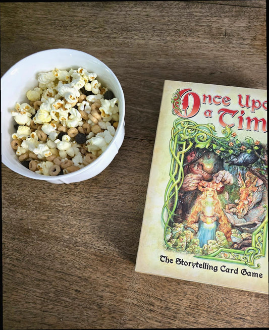 storytelling game night setup with Once Upon a Time card game and snack mix in bowl
