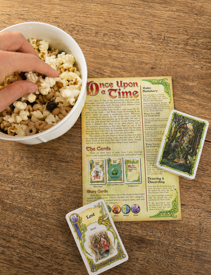 family playing storytelling card game with snack mix and cards on table